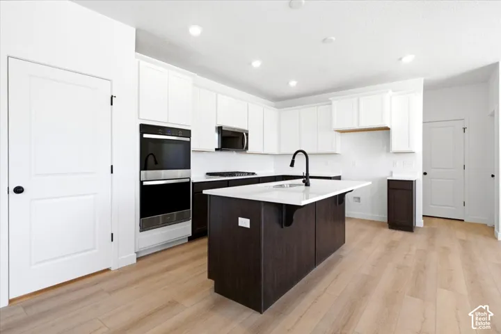 Modern kitchen with light wood-finish flooring and white walls