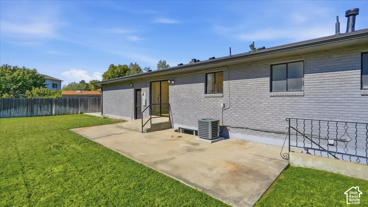 Expansive grassy yard with a concrete patio