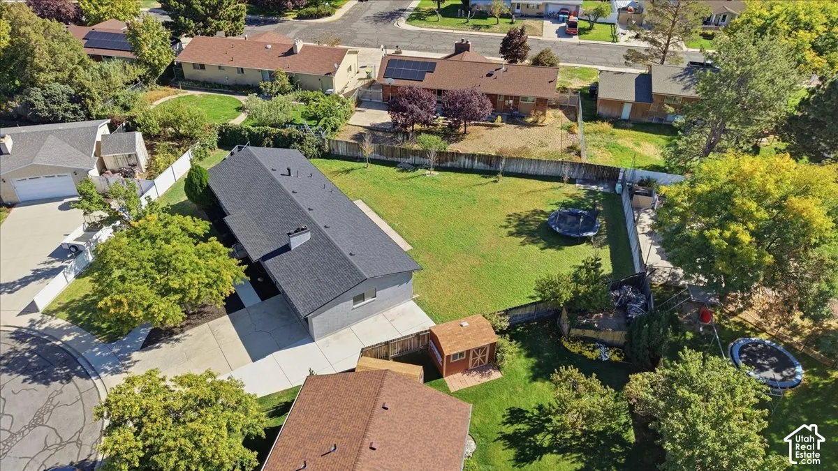 Expansive backyard featuring a large green lawn and mature trees