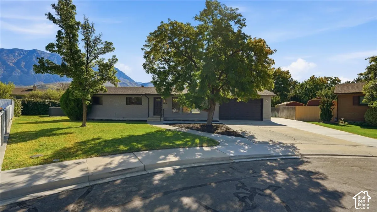 Single-story residence featuring a gray exterior, a two-car garage, and a concrete driveway
