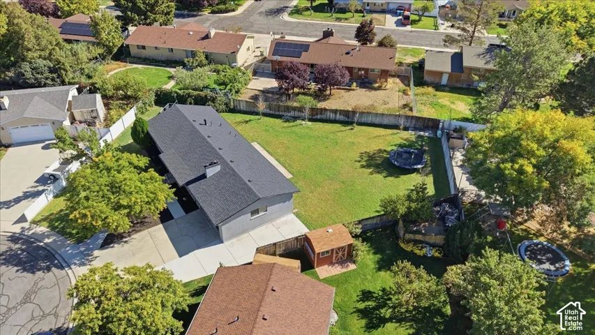 Expansive backyard featuring a large green lawn and mature trees