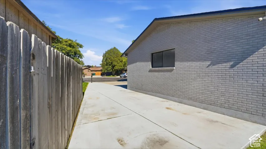 Concrete driveway alongside a gray brick exterior