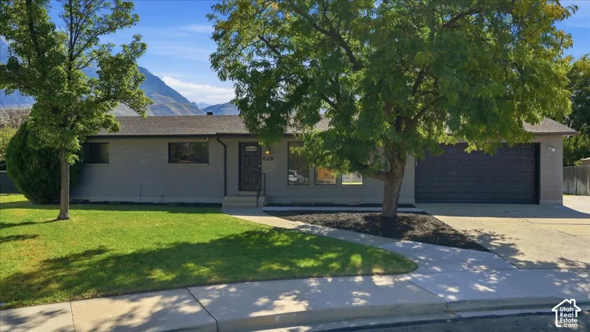 Single-story residence featuring a gray exterior, dark entry door, and an attached two-car garage