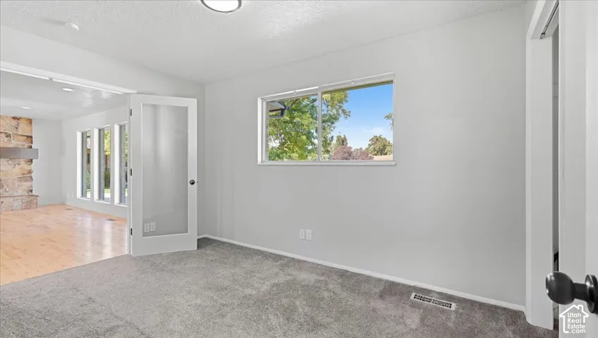 Light-colored carpeting, white walls, and a window with natural light