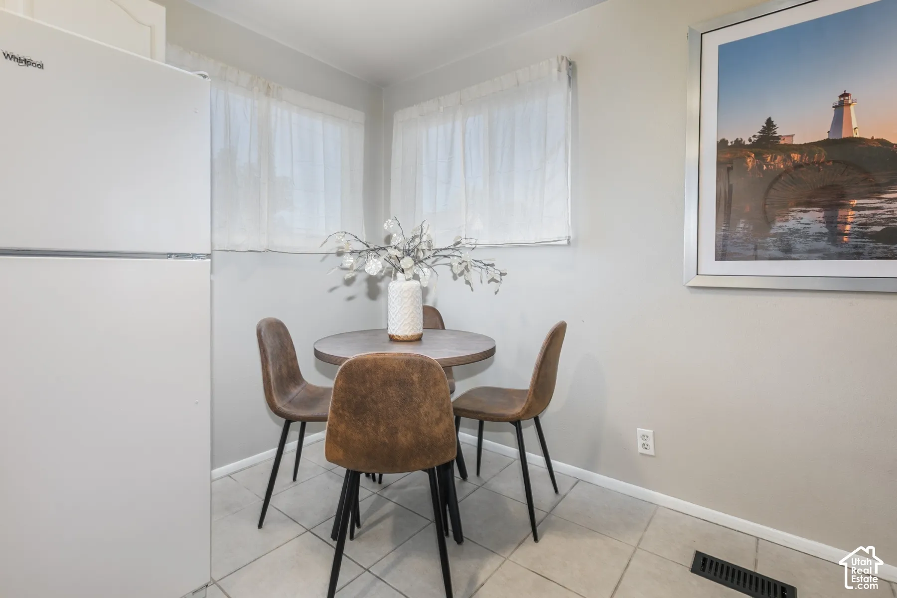 White Whirlpool refrigerator, light gray painted walls, and tiled flooring