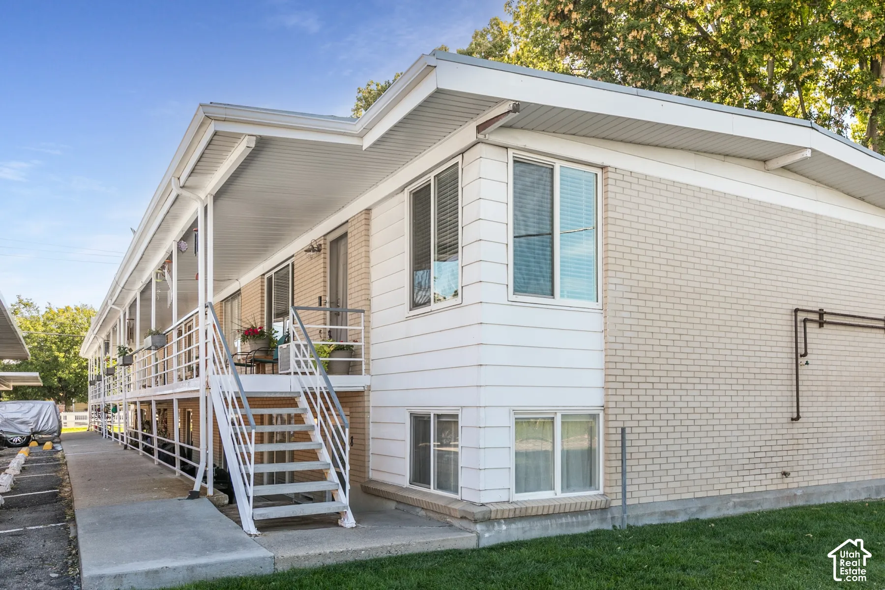 Multi-level structure featuring light-colored brick and white siding
