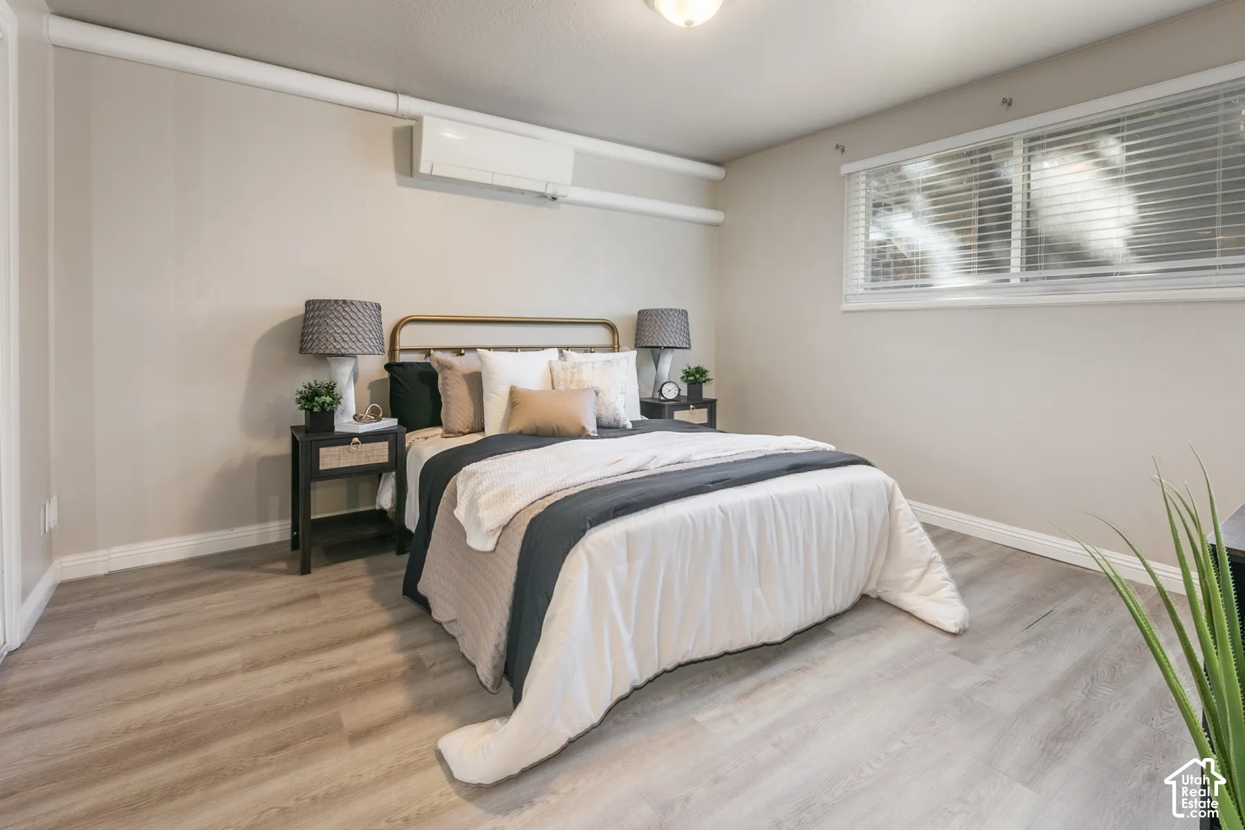 Wood-finish flooring, recessed lighting, and a wall-mounted climate control unit