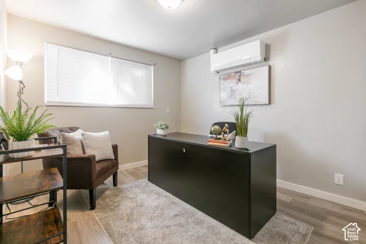 Wood-finish flooring, neutral wall tones, and a window with blinds