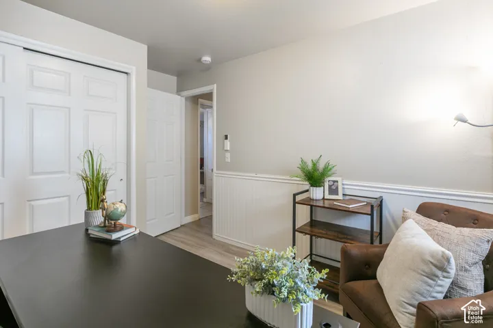 Wood-finish flooring, white paneled doors, and wainscoting with chair rail detailing