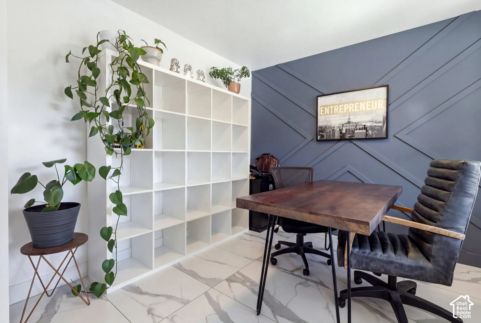 White built-in shelving, accent wall with geometric paneling, and white tile flooring with veining