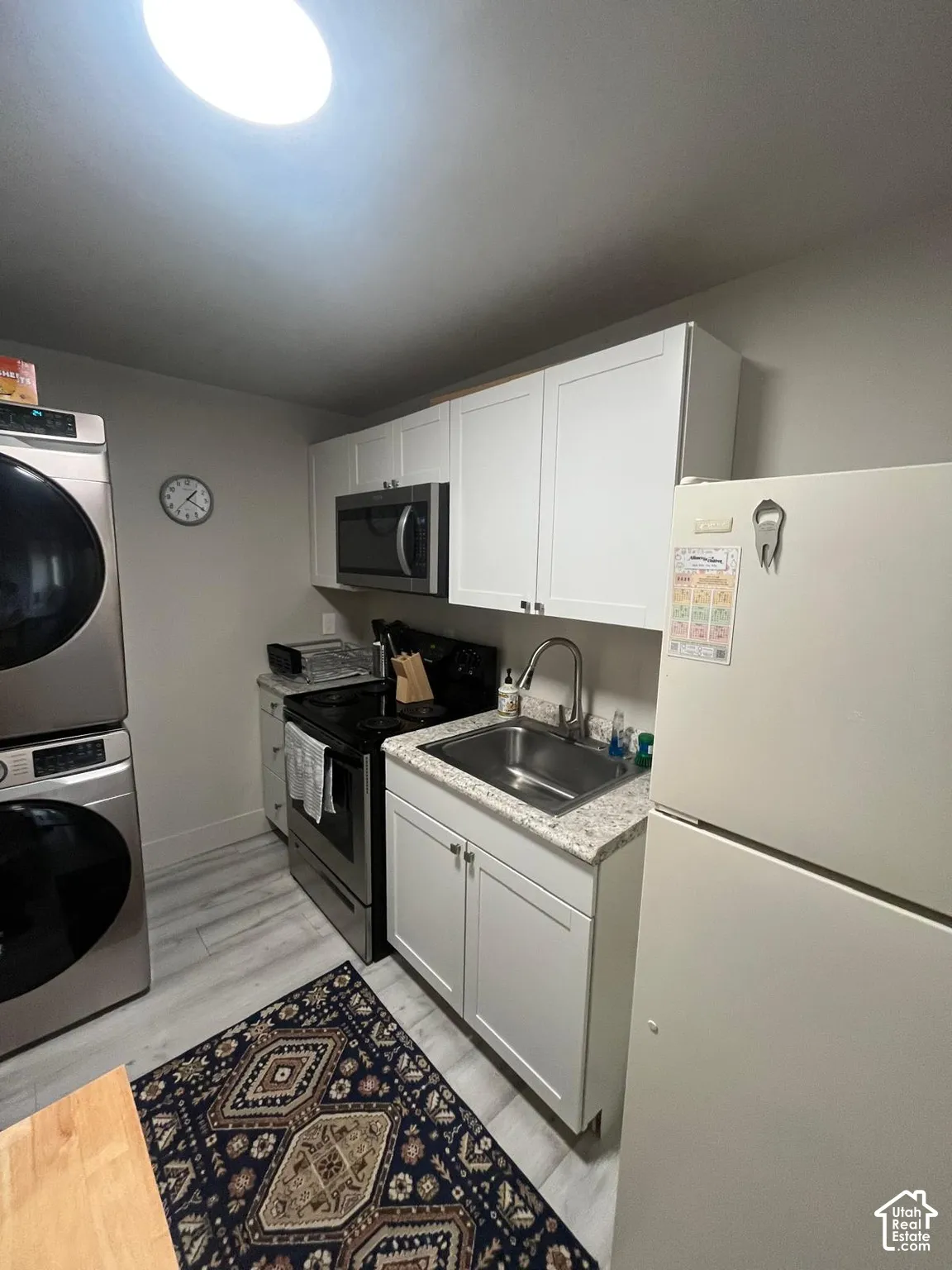 Compact kitchen featuring light-toned cabinetry, stainless steel sink, and light-toned countertops