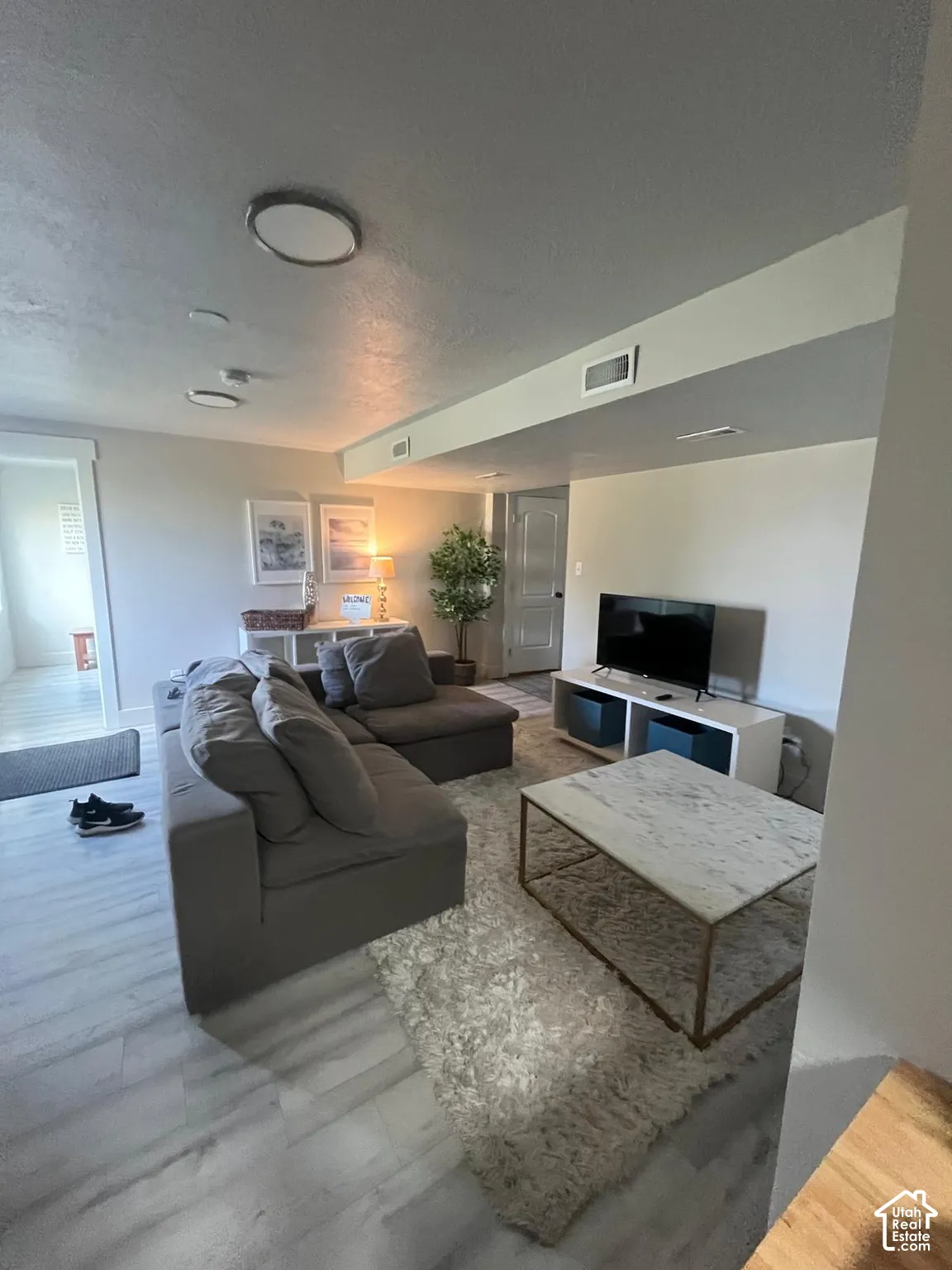Recessed lighting, wood-finish flooring, white door, and a built-in wall niche