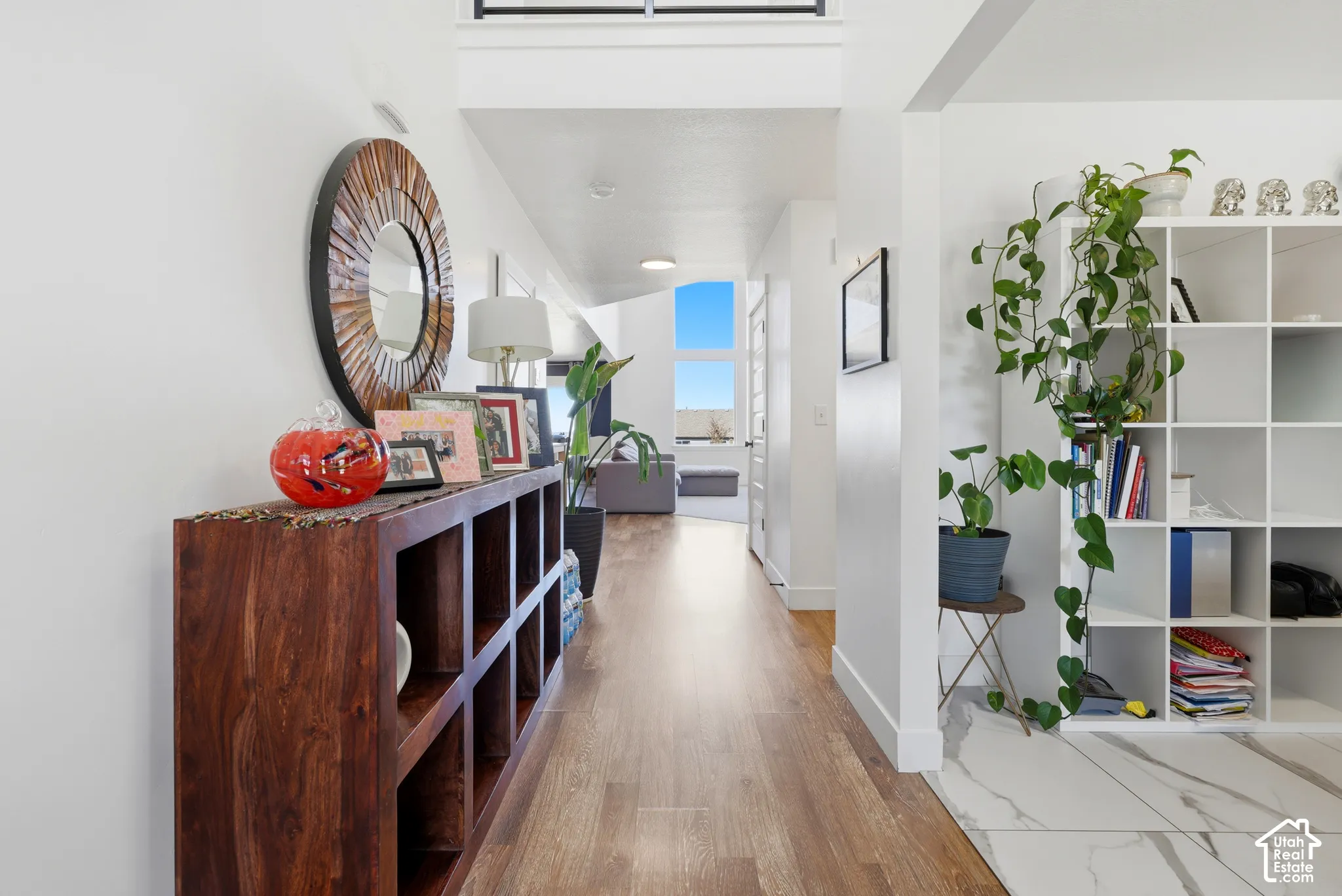 Wood-finish flooring, white walls, and a built-in shelving unit with multiple compartments