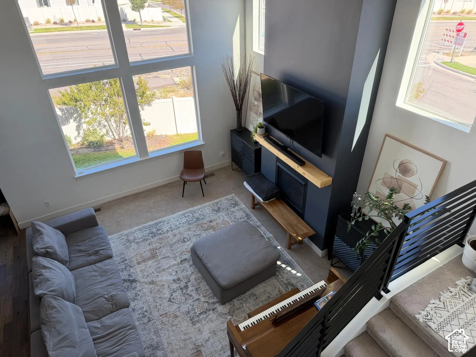 Two-story living area with expansive window wall, contemporary fireplace feature, and dark wood-finish flooring