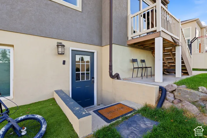 Welcoming entry featuring a navy blue door with multi-pane glazing and sidelights, complemented by a concrete landing and wood-finish doormat