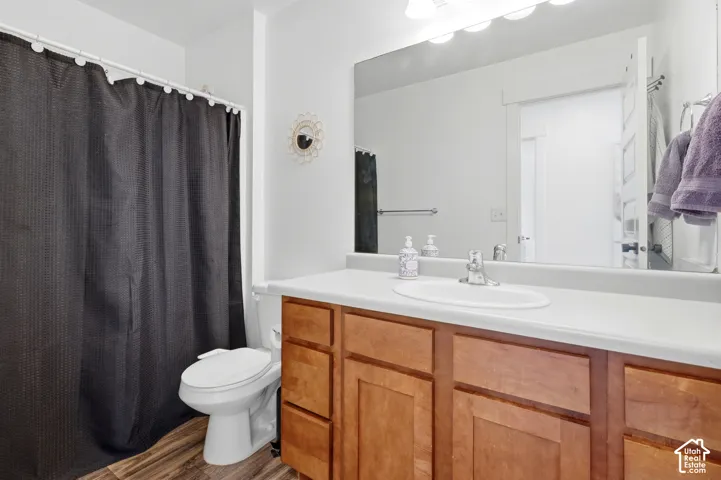 Spa-inspired primary bathroom featuring a wood-finish vanity with dual sinks, white quartz countertop, and an expansive framed mirror