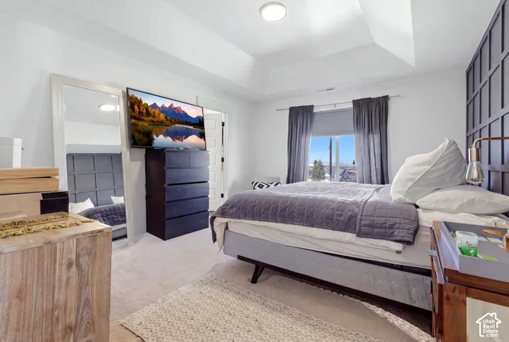 Tray ceiling, recessed lighting, wall-mounted accent paneling, and an expansive window