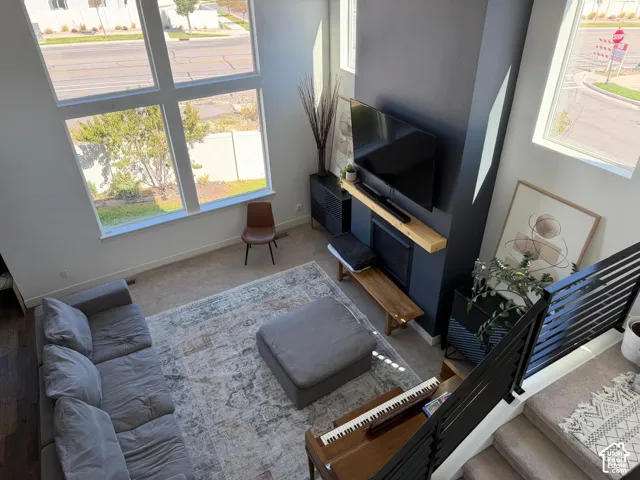 Two-story living area with expansive window wall, contemporary fireplace feature, and dark wood-finish flooring