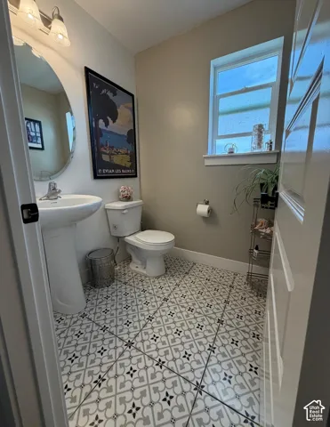 Pedestal sink with a wall-mounted mirror and two-light vanity fixture