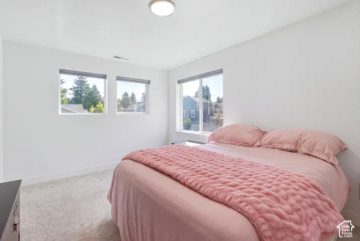 White walls, carpeted flooring, and a flush-mount ceiling light