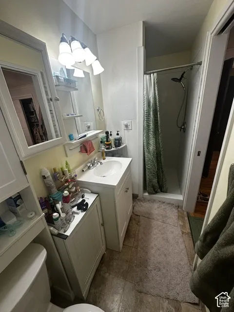 Vanity with an integrated sink, polished chrome faucet, and a wall-mounted mirror with overhead lighting