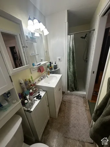 Vanity with an integrated sink, polished chrome faucet, and a wall-mounted mirror with overhead lighting