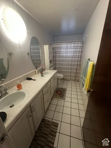 Dual vanity with undermount sinks, white cabinetry, and a light-colored countertop