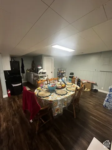 Wood-finish flooring with light-toned wall paneling and a drop ceiling