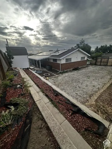 Single-story residence featuring brick and siding exterior, covered patio, and installed solar panels