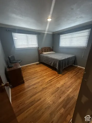 Wood-finish flooring throughout, complemented by two windows with blinds