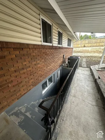 Brick and siding exterior with basement access via exterior stairs