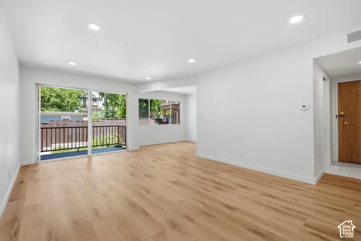 Wood-finish flooring throughout, recessed lighting, and white walls