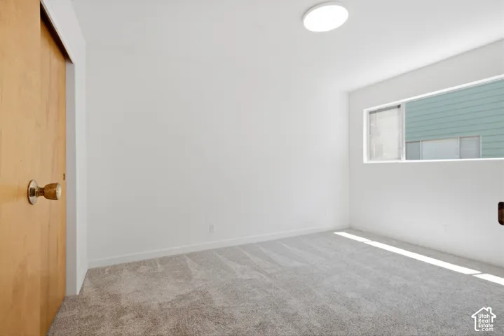 Recessed window with white trim, flush-mount ceiling light, and light brown wood-finish door
