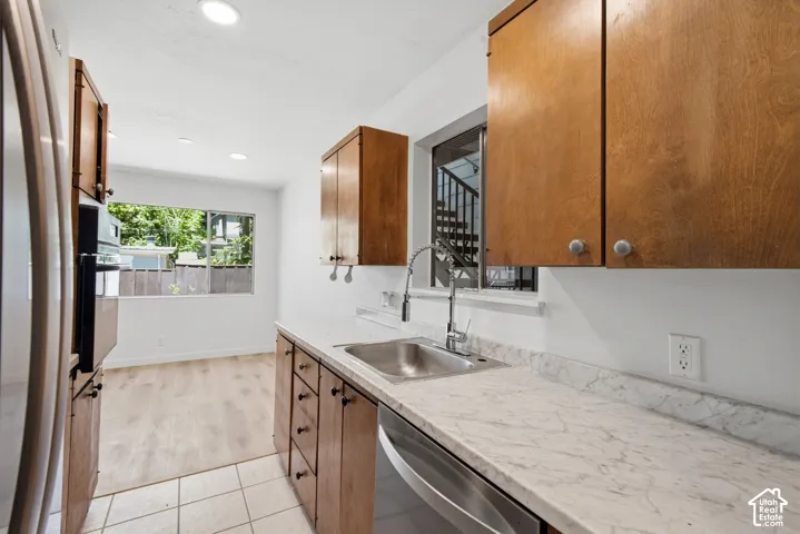 Kitchen featuring wood cabinetry, stainless steel sink, white countertops, and recessed lighting