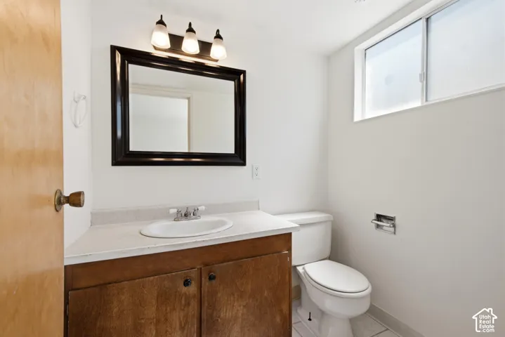 Wood-finish vanity with a white countertop and undermount sink