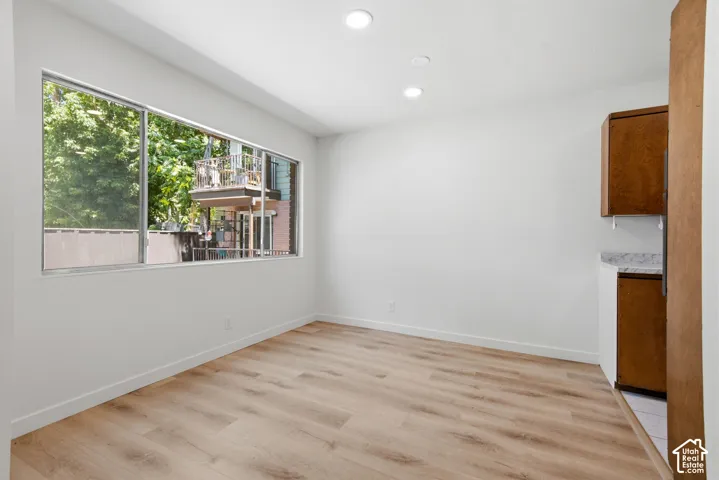 Recessed lighting, wood-finish flooring, and white walls