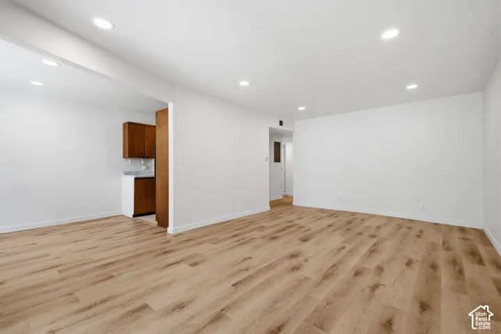 Recessed lighting, wood-finish flooring, white walls, and white trim