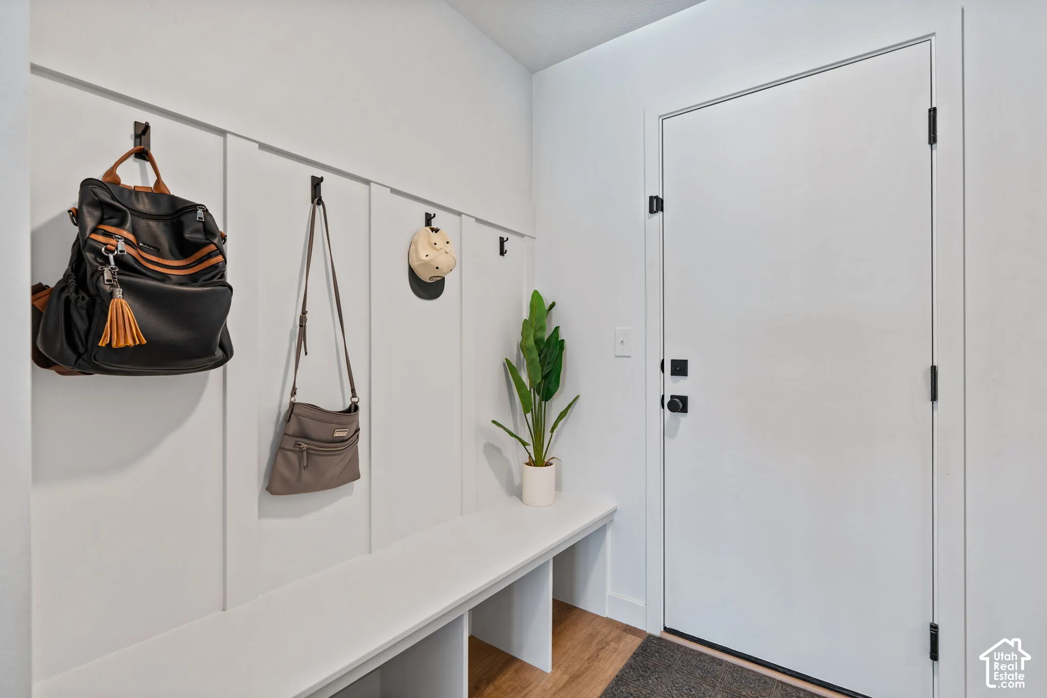 Built-in bench with storage, board and batten wall paneling, and black hardware