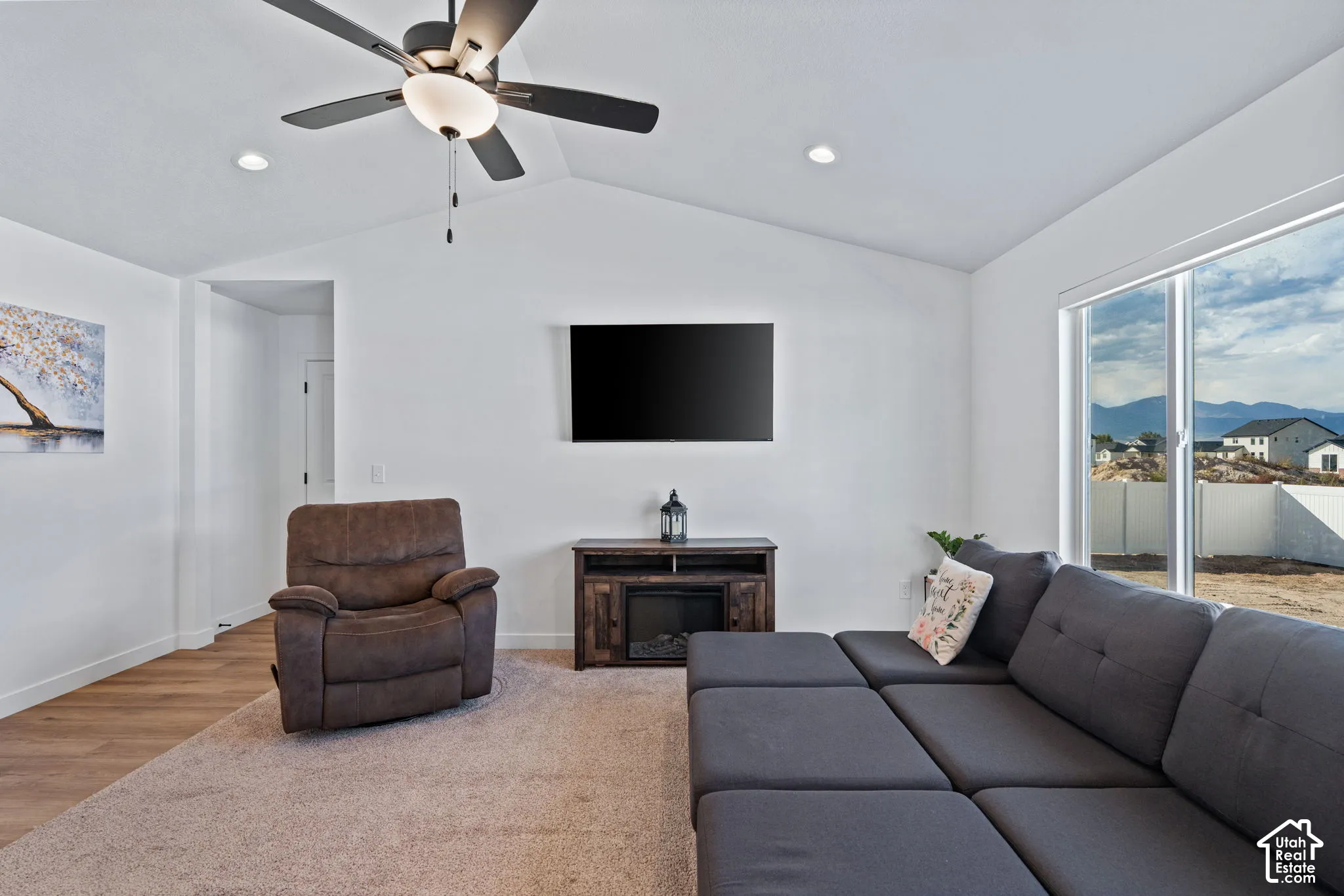 Vaulted ceiling with a ceiling fan, recessed lighting, wood-finish flooring, and a sliding glass door