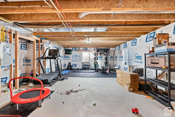 Unfinished basement featuring exposed wood joists, concrete flooring, and roughed-in framing