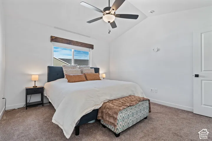 Vaulted ceiling with a ceiling fan, recessed window with a wood header, and a paneled door