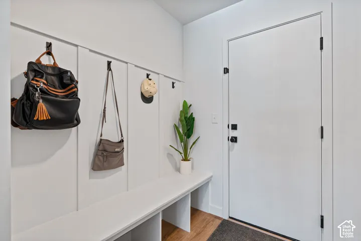 Built-in bench with storage, board and batten wall paneling, and black hardware