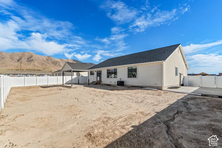 Expansive lot with a newly constructed residence featuring a white stucco exterior and a dark shingle roof