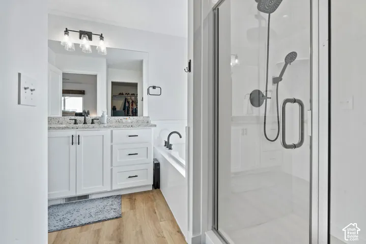 White vanity with a stone-finish countertop, undermount sink, and black fixtures