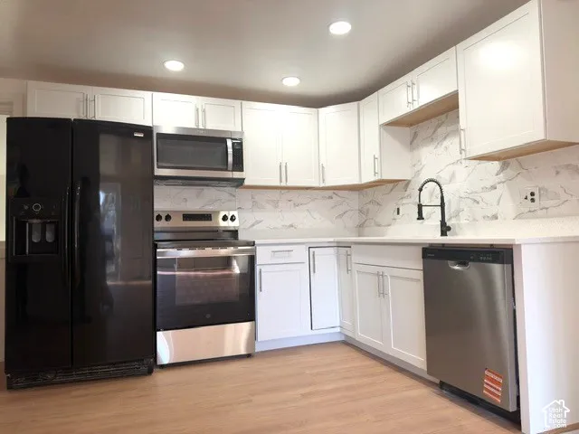 Kitchen featuring white cabinetry,  countertops,