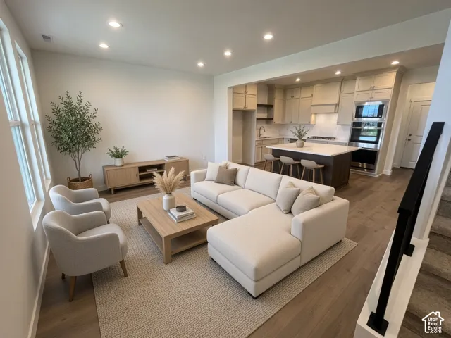 Open concept living space featuring wood-finish flooring, recessed lighting, and a modern kitchen