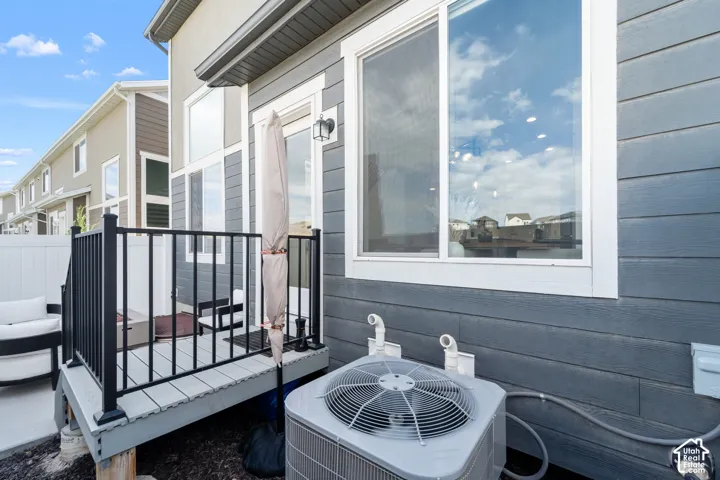 Exterior featuring horizontal siding, a sliding patio door, and a built-in outdoor deck with black railings