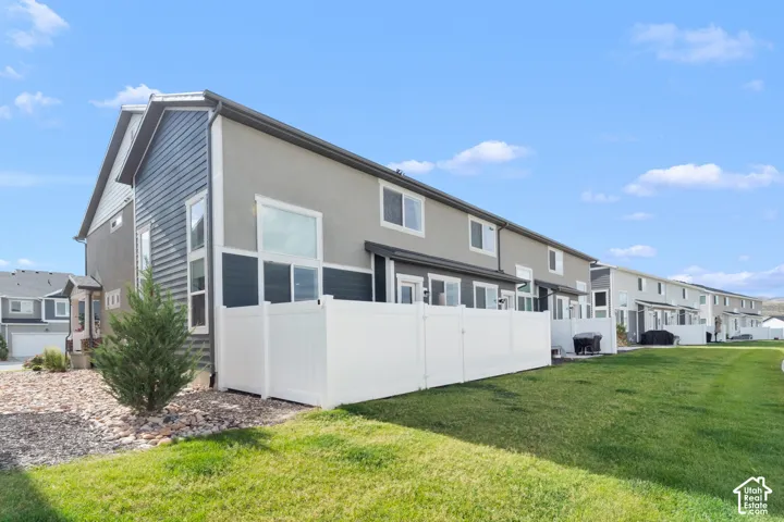 Contemporary exterior with multi-toned siding, white frame windows, and a private rear patio area