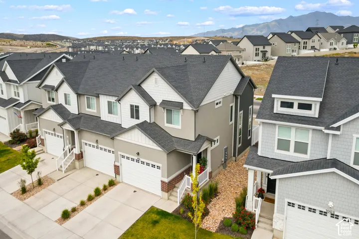 Modern townhome exterior with mixed siding, attached garage, and mountain backdrop