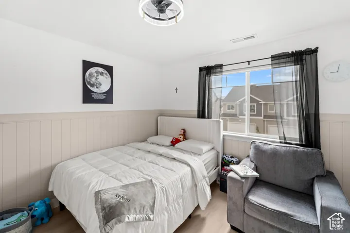 Light wood-finish flooring, white walls, and wainscoting detailing